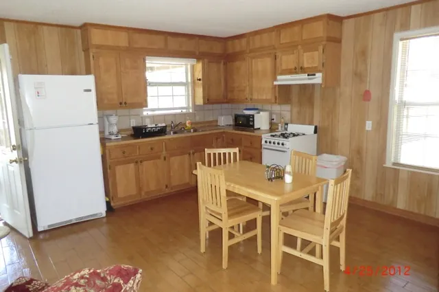 Cabin kitchen with full-size fridge, stove and dining table